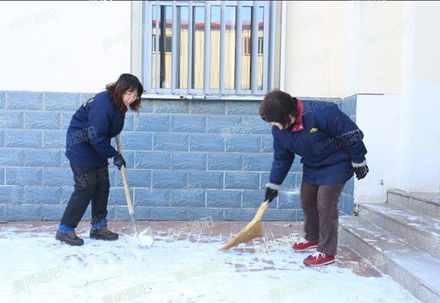 揮舞著鐵鍬和笤帚，相互配合掃雪圖片